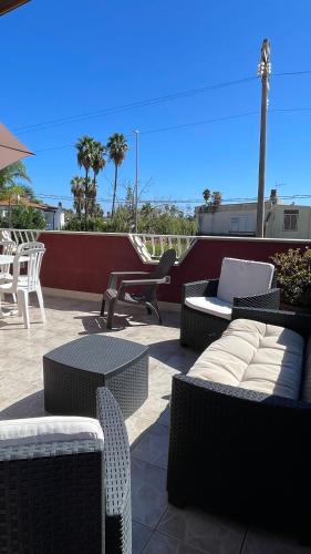 a patio with wicker furniture and a table and chairs at Villa Lucia in Ognina