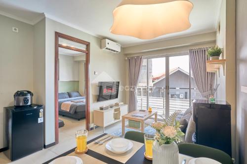 a living room with a couch and a table at Eazystay Gateway Pasteur Apartment in Bandung