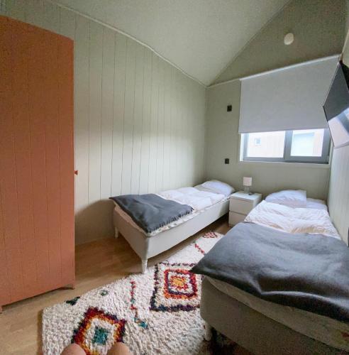 a bedroom with two beds and a rug at Viste Funäsdalen in Funäsdalen