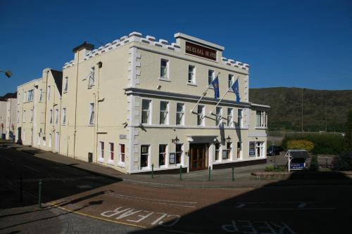 
a large brick building with a clock on the side of it at The Imperial Hotel in Fort William
