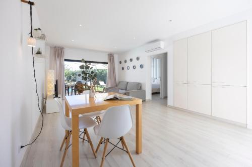 a kitchen and dining room with a wooden table and white cabinets at Villa Jump Jibe in Sagres