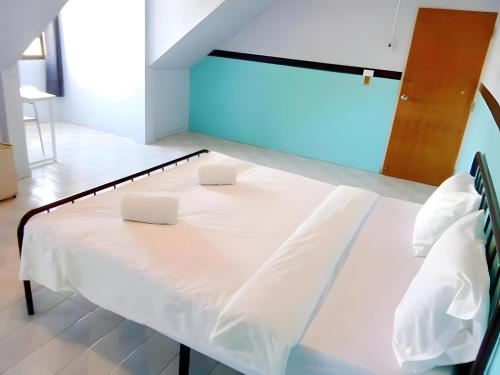 a bed with two white pillows on it in a room at xx Mitr Inn - Phuket Old Town มิตรอินน์ ภูเก็ต เมืองเก่า 3 in Phuket