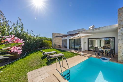 a backyard with a swimming pool and a house at Villa Jump Jibe in Sagres