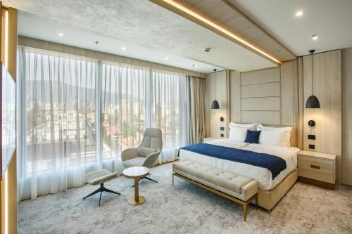 une chambre avec un lit et une grande fenêtre dans l'établissement East Plaza Hotel, à Sofia