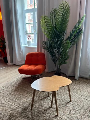 a living room with a red chair and a coffee table at K2-Project - Kleines Loft beim Schlossteich in Chemnitz