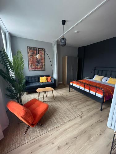 a bedroom with a bed and a couch and a chair at K2-Project - Kleines Loft beim Schlossteich in Chemnitz
