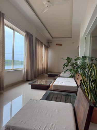 a room with pillows and plants and a window at Nadhi Mane River-front Beach Stay in Tadri