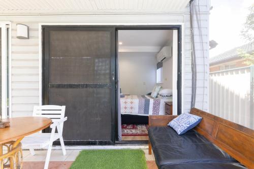 a screened in porch with a couch and a bedroom at Zen Escape Guest House " Location 2" - Zen Garden Tiny Home, Nooky Studio, Chillax Rest in Brisbane