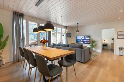 a dining room and living room with a table and chairs at Scenic Holiday Apartment with Balcony Views in Lungern