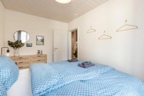 a bedroom with a blue bed and a mirror at Scenic Holiday Apartment with Balcony Views in Lungern