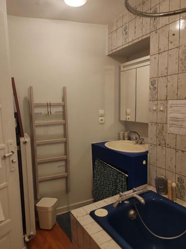 a bathroom with a blue tub and a sink at Chambre chez l'habitant in Grenoble