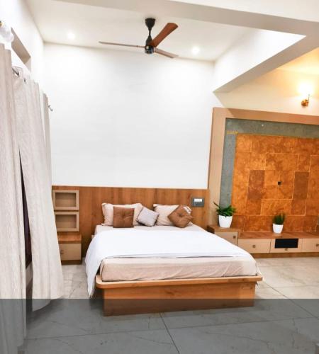 a bedroom with a bed and a ceiling fan at Green Glow Homestay in Chikmagalūr