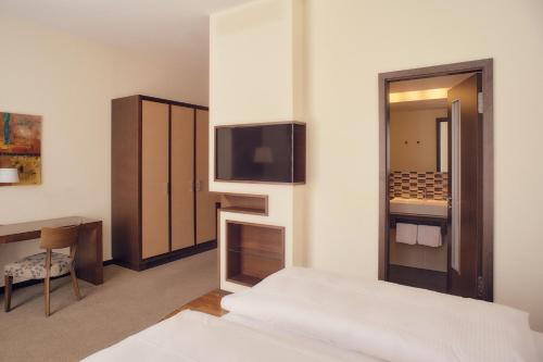 a hotel room with a bed and a tv on a wall at Aparthotel Treudelberg Hamburg in Hamburg