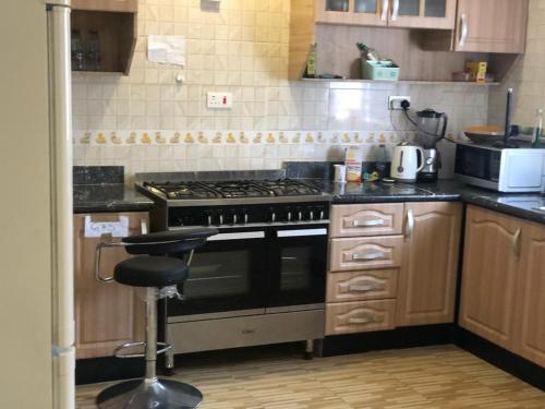 a kitchen with a stove and a stool in it at Eno Mary s home in North Legon