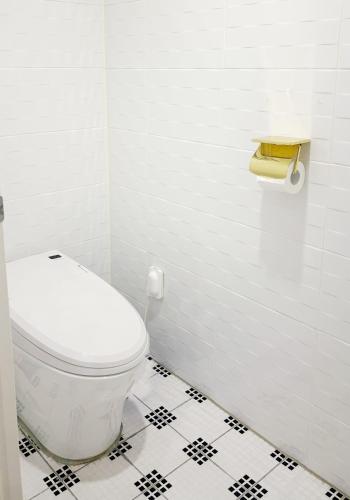 a bathroom with a white toilet and a black and white tile floor at Signature Tourist Hotel in Seoul