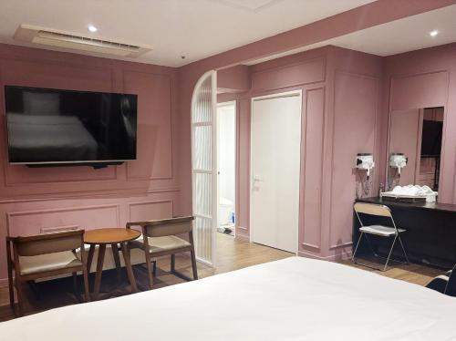 a bedroom with a bed and a tv on a wall at Signature Tourist Hotel in Seoul