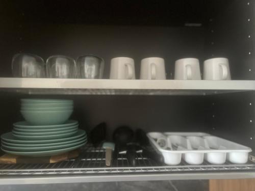 a shelf with plates and bowls and dishes in a refrigerator at Two Bedroom Riverland Apartment in VNO