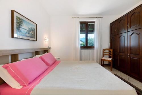 a bedroom with a large bed with pink sheets at Casa Lago - Dongo in Dongo