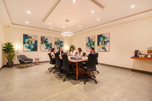 a group of people sitting around a table in a room at FabHotel High Rise - Marathalli in Bengaluru