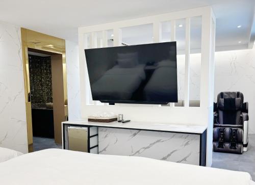 a large flat screen tv on a wall in a bedroom at Signature Tourist Hotel in Seoul