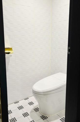 a bathroom with a white toilet and a tiled floor at Signature Tourist Hotel in Seoul