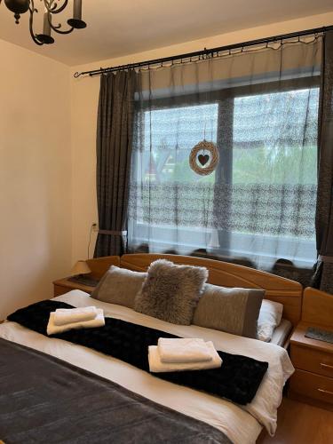 a bedroom with a large bed with a window at Bałamutka B&B in Poronin