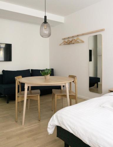 a dining room with a table and a couch at STUDIO1A Hotel Apartments in Copenhagen