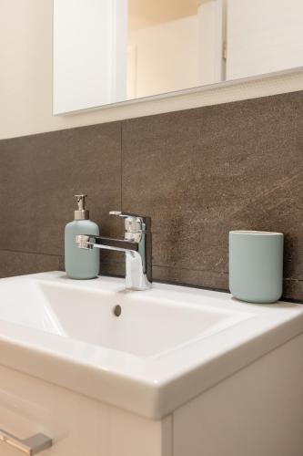 a bathroom sink with two cups on top of it at Scenic Holiday Apartment with Balcony Views in Lungern