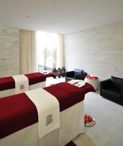 a room with three beds and chairs and a window at Altis Belem Hotel & Spa, a Member of Design Hotels in Lisbon