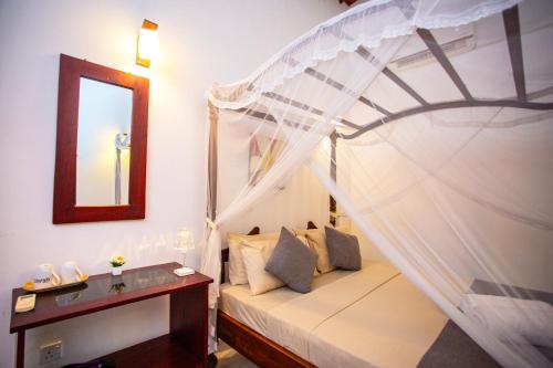 a bedroom with a bed with a canopy at Su Yu villa in Unawatuna