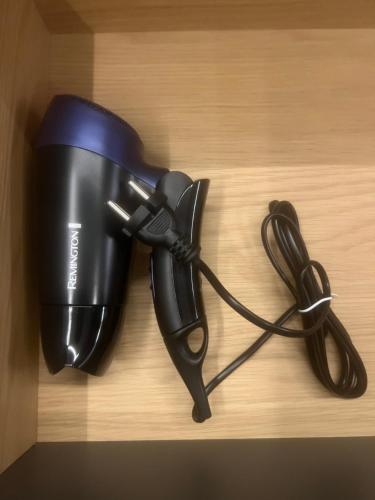 a hair dryer sitting on a wooden shelf with a cord at Two Bedroom Riverland Apartment in VNO