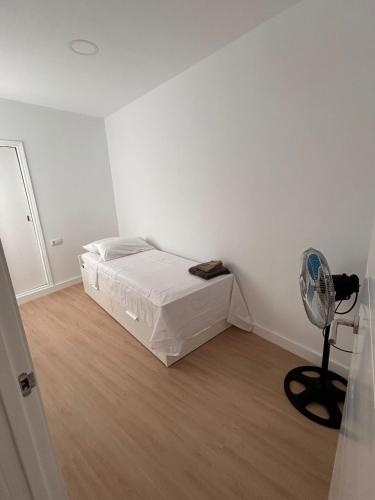 une chambre blanche avec un lit et un ventilateur dans l'établissement Padre Anchieta 35 - 8, à Santa Cruz de Tenerife
