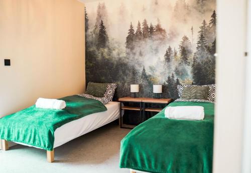 een slaapkamer met 2 bedden en een schilderij van bomen bij Domki Natura Zator in Graboszyce