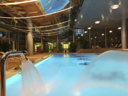 a large swimming pool in a large building at La Cigale Hotel Managed by Accor in Doha