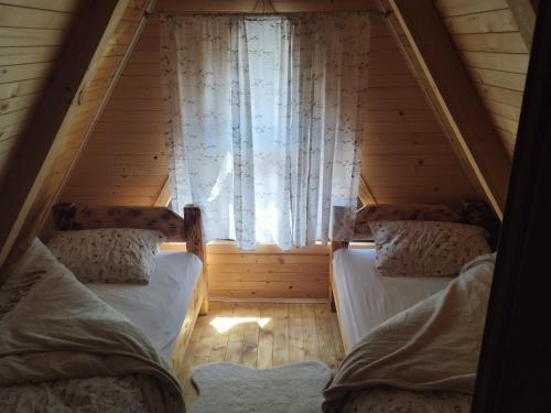 a attic room with two beds and a window at Pax Montana in Blidinje