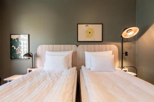 two beds sitting next to each other in a room at Scandic Helsinki Station in Helsinki