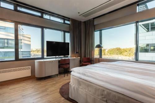 a bedroom with a large bed and large windows at Scandic Helsinki Station in Helsinki