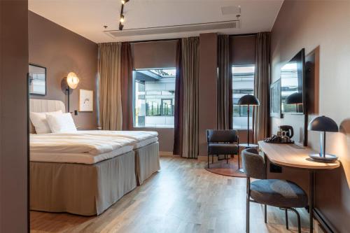 a hotel room with a bed and a desk at Scandic Helsinki Station in Helsinki