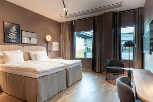 a hotel room with a bed and a table and chairs at Scandic Helsinki Station in Helsinki