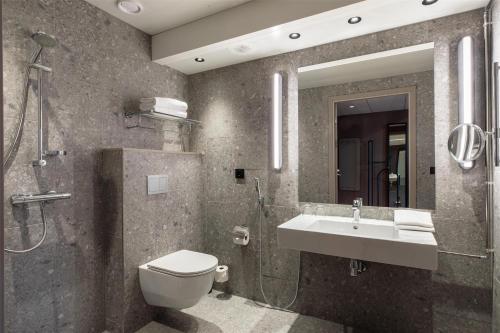 a bathroom with a sink and a toilet and a shower at Scandic Helsinki Station in Helsinki