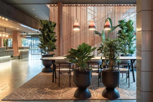 a restaurant with a table and chairs with plants at Scandic Helsinki Station in Helsinki