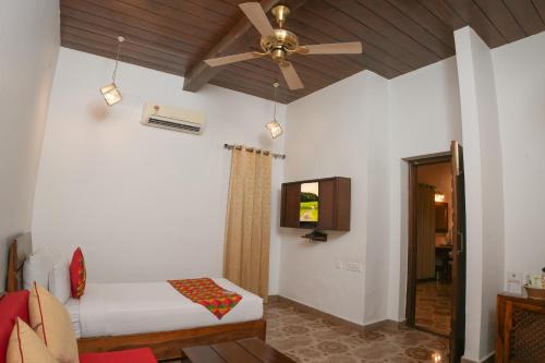 a bedroom with a bed and a ceiling fan at Sadda Pind Amritsar in Amritsar