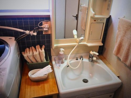 a small bathroom with a sink and a mirror at 天宿りAmayadori in Ise