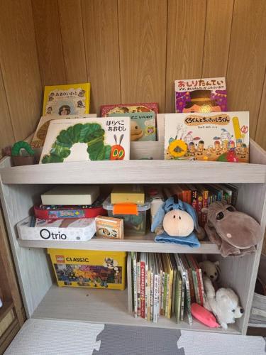 a book shelf filled with lots of toys and books at 天宿りAmayadori in Ise