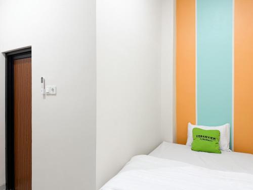 a bedroom with a green pillow on a bed at Urbanview Hotel Simple near Pakuwon Mall Jogja in Seturan