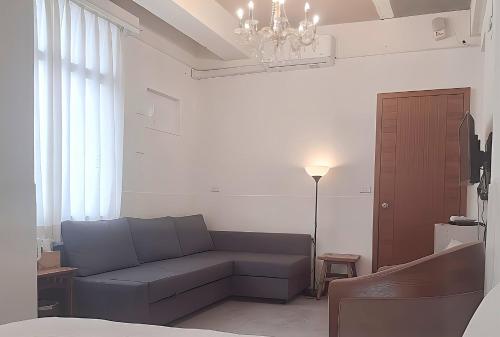 a living room with a couch and a chandelier at 山露露品茶 70年代老房子 二樓背包 4-5樓合併 六人包層 Te en Te' Guesthouse in Tainan