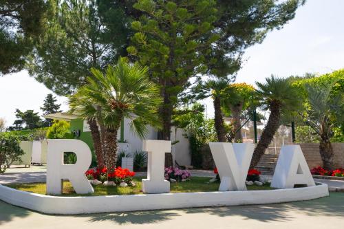 a sign for the park with palm trees and flowers at Hotel Riva Del Sole in Giovinazzo