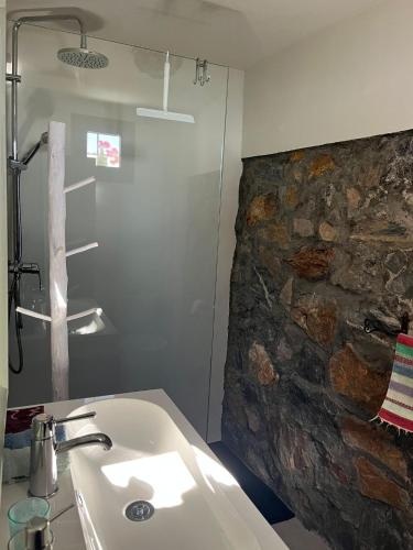 a bathroom with a sink and a stone wall at La Ladera Bay View in La Herradura