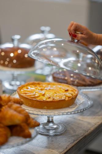 a person is making a pie on a table at Hotel Riva Del Sole in Giovinazzo