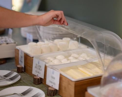 a person is reaching for a box of cheese at Hotel Riva Del Sole in Giovinazzo